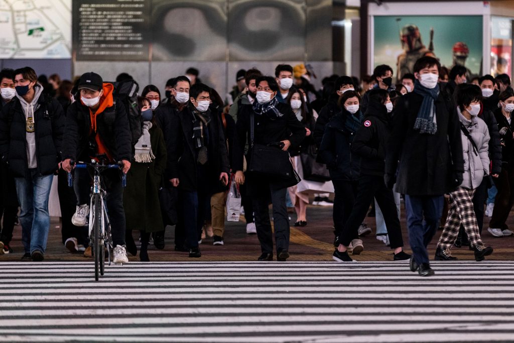 People wearing face masks walk at Shibuya crossing in Tokyo. (AFP)