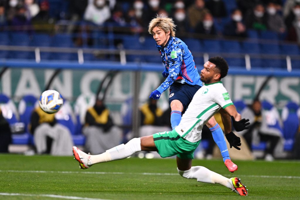 Japan's Junya Ito (L) is challenged by Saudi Arabia's Ali Albulayhi during the FIFA World Cup Qatar 2022 Asian zone qualification football match between Japan and Saudi Arabia at Saitama Stadium in Saitama on February 1, 2022. (AFP)