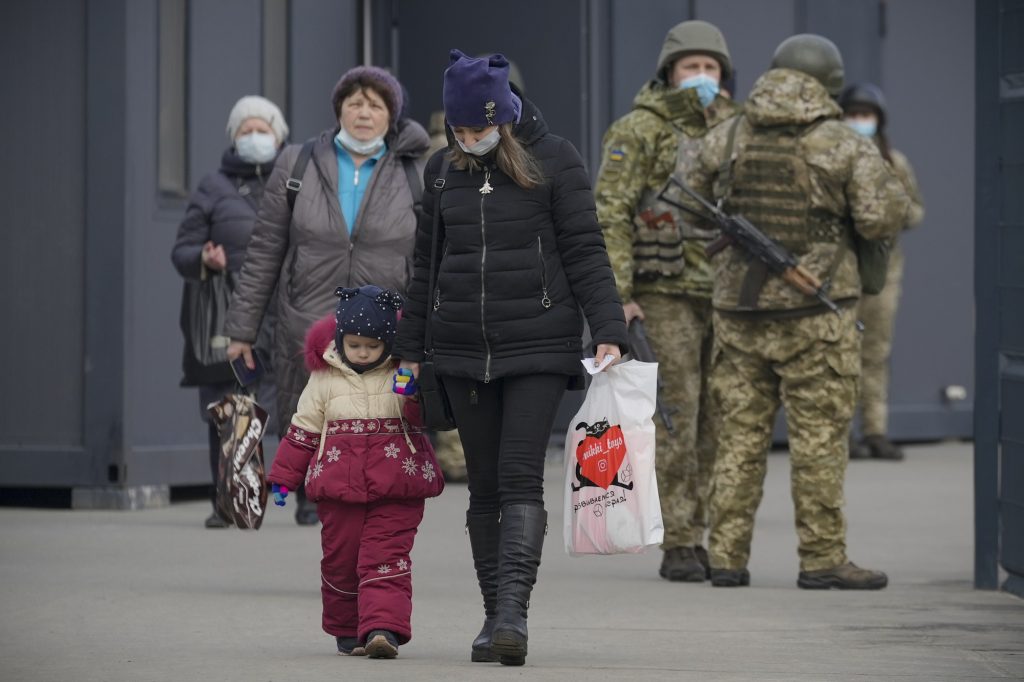 A woman holds a child's hand as they cross from Ukrainian government to pro-Russian separatists controlled territory in Stanytsia Luhanska, the only crossing point which is open daily, in the Luhansk region, eastern Ukraine, Feb. 11, 2022. (File photo/AP)
