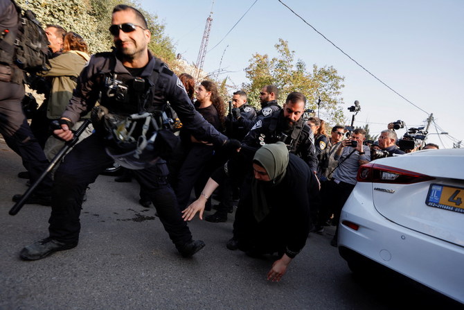 A member of the Israeli security forces pulls a Palestinian woman during a protest in the Sheikh Jarrah neighbourhood of East Jerusalem, February 18, 2022. (Reuters)