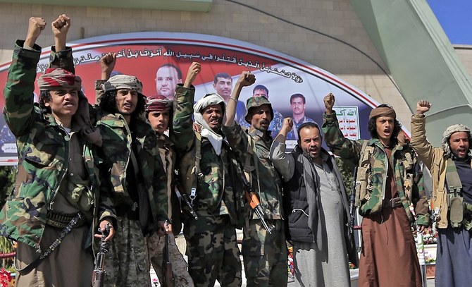 Houthi fighters raise their fists and chant slogans in Sanaa, Yemen. (File/AFP)