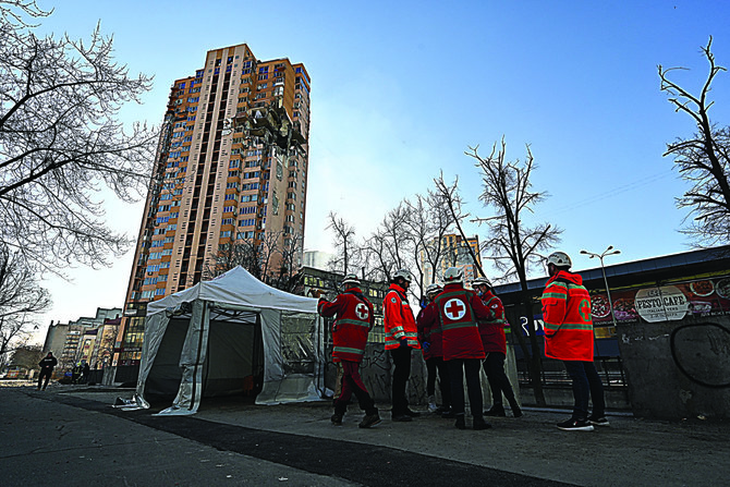 Medics gather by a high-rise apartment block which was hit by recent shelling in Kyiv on Feb. 26, 2022. (Genya Savilov / AFP)