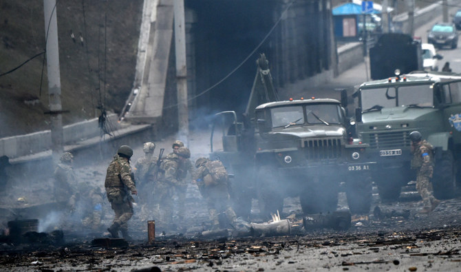 Ukrainian soldiers collect unexploded shells after a fighting with Russian raiders in Kyiv in the morning of Feb. 26, 2022. (Photo by Sergei Supinsky / AFP)