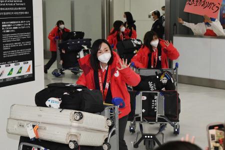 Satsuki Fujisawa (front) and other members of the Japanese women's curling team wave as they arrive at Narita Airport in Chiba prefecture on February 21, 2022, following their silver medal win at the 2022 Winter Olympics in Beijing. (AFP)