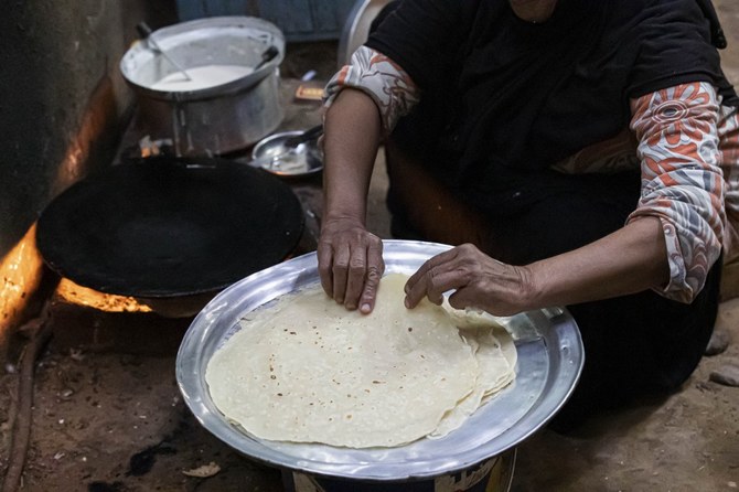 An Egyptian woman prepares bread for the family in her home at Zerzara village on the west bank of the Nile river, off of Egypt's southern city of Aswan. (File/AFP)