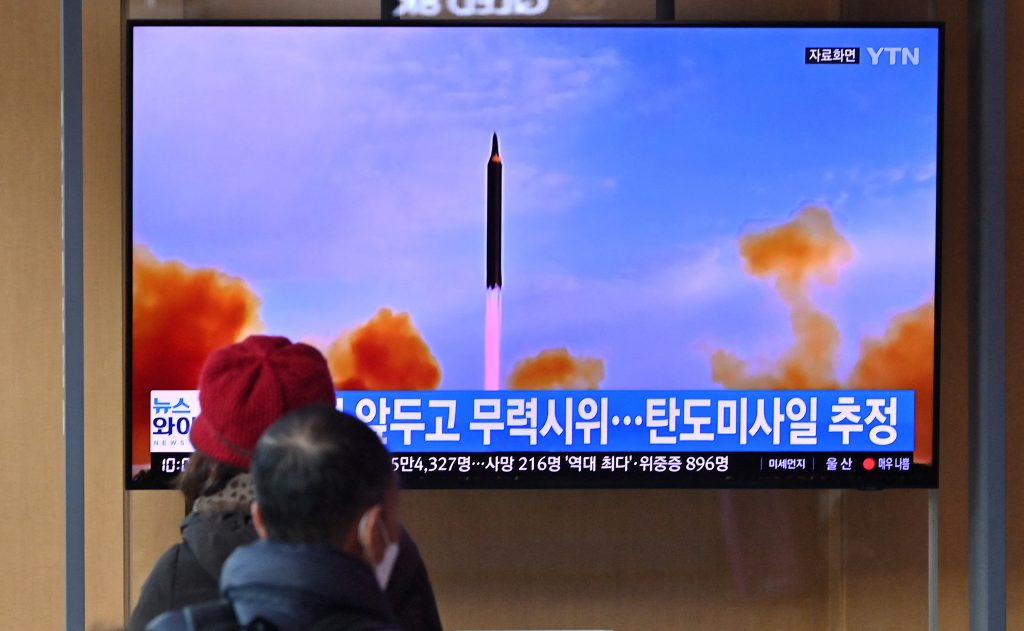 People watch a television screen showing a news broadcast with file footage of a North Korean missile test, at a railway station in Seoul, March. 5, 2022. (AFP)