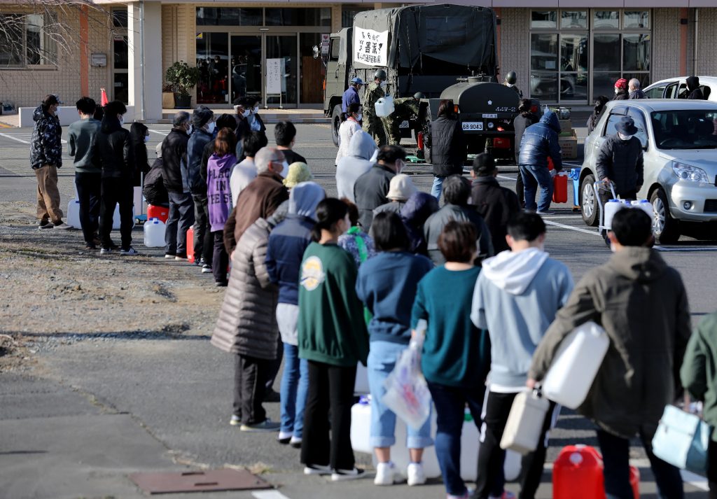 In Osaki, Miyagi, where about 10,000 homes were without water, Self-Defense Forces troops set up water supply stations. (AFP)