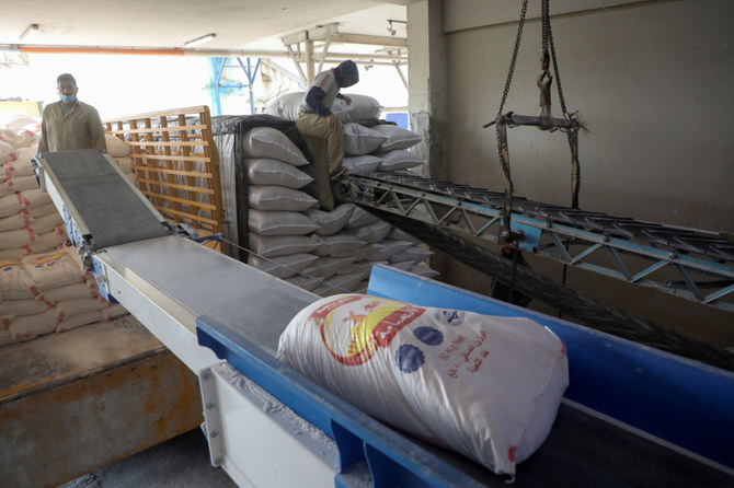 Men load sacks of wheat flour into trucks at a mill in Beirut, Lebanon. (Reuters)