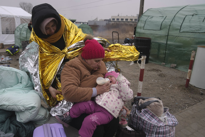 A woman feeds a baby after fleeing from the Ukraine and arriving at the border crossing in Medyka, Poland, Monday, March 7, 2022. (AP)