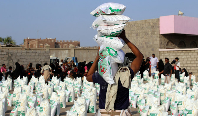 Workers prepare food aid and provisions to be distributed to displaced people at a camp in Yemen’s Hodeida province. (AFP/File)