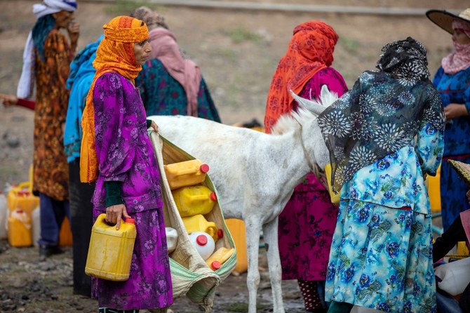 Yemeni women fill their jerricans with water from a tanker in the southwestern Taiz Governorate. (File/AFP)