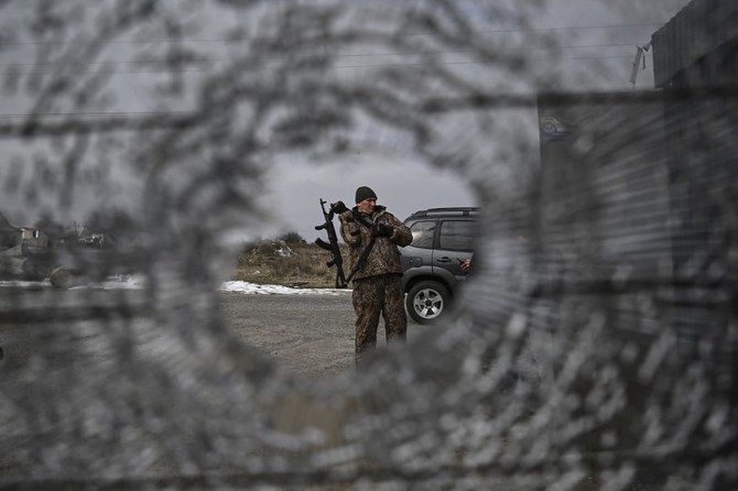 Above, a Ukrainian serviceman stands at a check point in the vilage of Velyka Dymerka east of Kyiv, on March 9, 2022. (AFP)