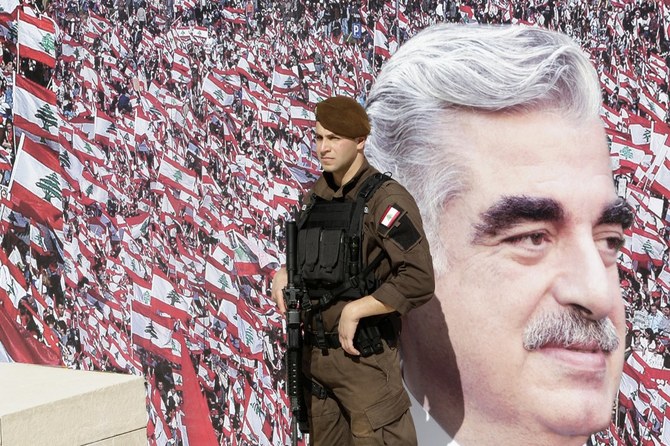 A member of the Lebanese security forces stands guard in front of a billboard bearing a portrait of slain former Lebanese PM Rafik Hariri in downtown Beirut. (File/AFP)