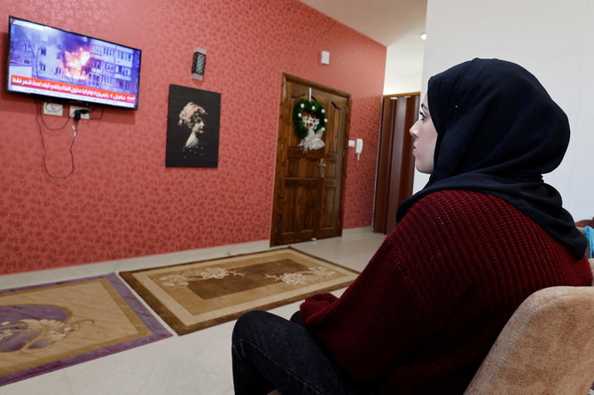 Palestinian university student Samar Aita, who studied in Ukraine, watches news about Ukraine's invasion by Russia at her house, in Rafah in the southern Gaza Strip, March 13, 2022. Reuters)