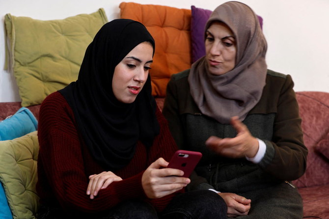 Palestinian university student Samar Aita, who studied in Ukraine, chats with her mother at her house, in Rafah in the southern Gaza Strip, March 13, 2022. Picture taken March 13, 2022. (Reuters)