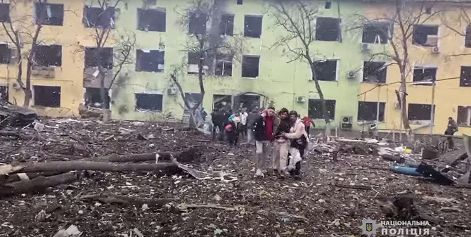 People are helped out of a damaged building of a children's hospital following a Russian air strike in the southeastern city of Mariupol on March 9, 2022. (AFP)
