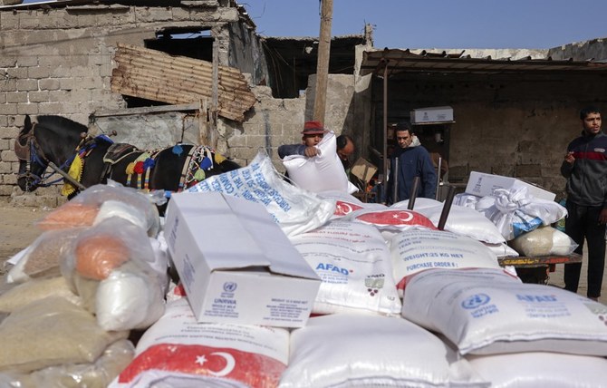 Palestinians collect food aid at a distribution center run by UNRWA in Gaza City. (File/AFP)