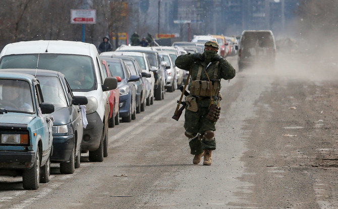 Pro-Russian troops check cars as local residents leave the besieged southern port city of Mariupol, Ukraine, on March 17, 2022. (Reuters)