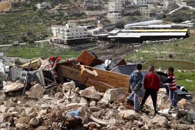 Palestinian boys look at the belongings of a Palestinian family after their home was demolished by Israeli forces, south of Hebron. (File/AFP)