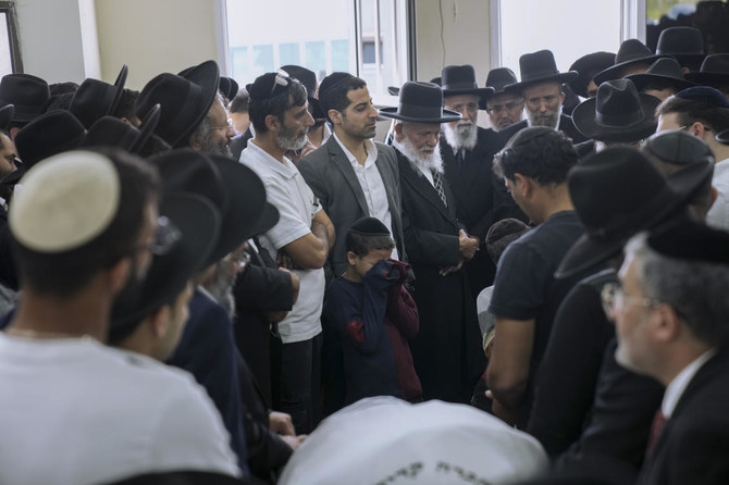 Mourners gather around the body of Yaakov Shalom, 36, at a cemetery in Petah Tikva, Israel, on Wednesday. Shalom was one of five killed by a gunman in a crowded city in central Israel late Tuesday. (AP)