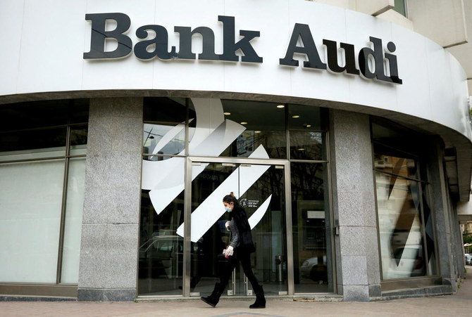 A woman wearing a face mask walks by a closed branch of Bank Audi after Lebanon declared a state of emergency over the spread of the coronavirus in Lebanon. (Reuters)