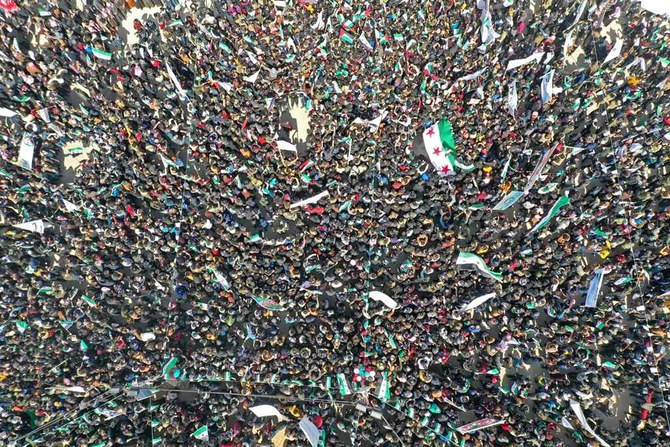 An aerial view shows Syrians gathering on the main square in Syria’s rebel enclave of Idlib on Tuesday marking 11 years since an anti-regime uprising. (AFP)