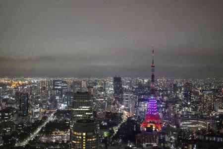 The Tokyo Tower is seen partially lit as part of energy-saving measures following a government electricity supply warning for the capital and surrounding areas, in Tokyo on March 22, 2022. (AFP)