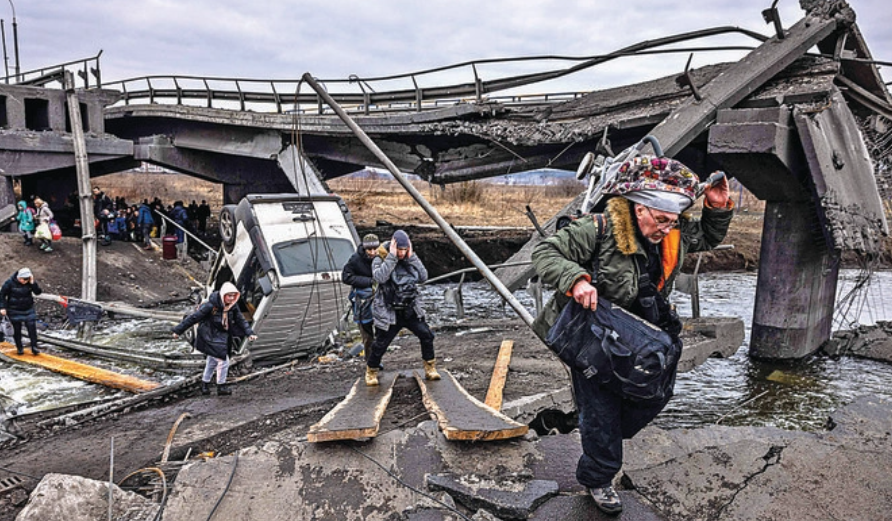 Ukrainian refugees cross a destroyed bridge on Monday as they flee the city of Irpin, northwest of Kyiv, amid calls for safe evacuation routes for civilians. (AFP)