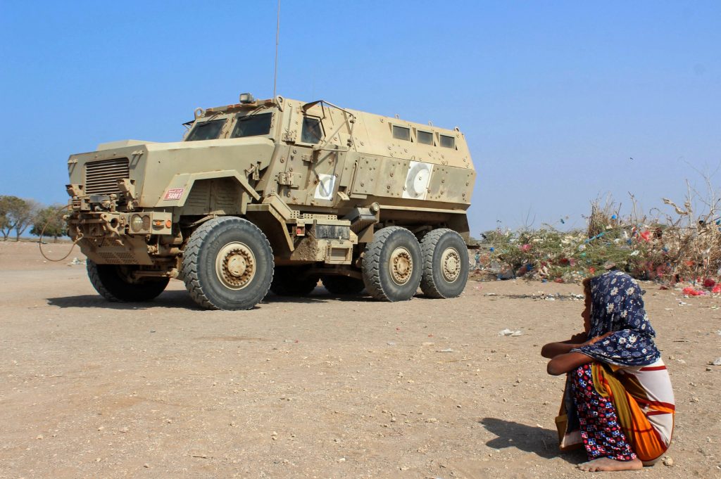 A displaced Yemeni girl sits next to an armoured military vehicle at a camp in the Khokha district of the western province of Hodeida, on January 21, 2019. (AFP)