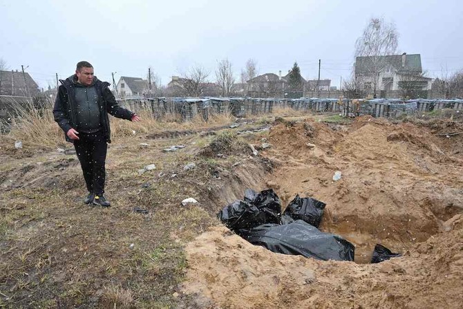 A man gestures at a mass grave in the town of Bucha, northwest of the Ukrainian capital Kyiv on April 3, 2022. (AFP)