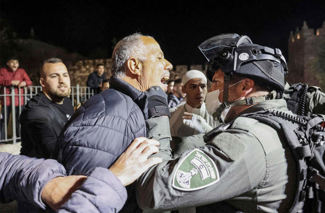 A Palestinian man argues with Israeli border guards during clashes between Palestinians and Israeli security forces near the Damascus of the old city of Jerusalem late on April 3, 2022. (AFP)