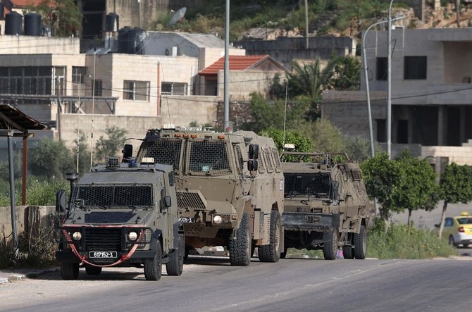 Israeli vehicles are positioned at the entrance of the Nur Shams Palestinian refugee camp near in the northern West Bank town of Tulkarem on April 10,2022l. (AFP)
