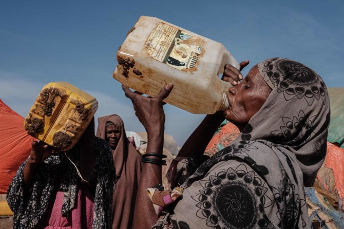 In this file photo taken on February 13, 2022 Hawa Mohamed Isack (R), 60, drinks water at a water distribution point at Muuri camp, one of the 500 camps for internally displaced persons (IDPs) in town, in Baidoa, Somalia. (AFP)