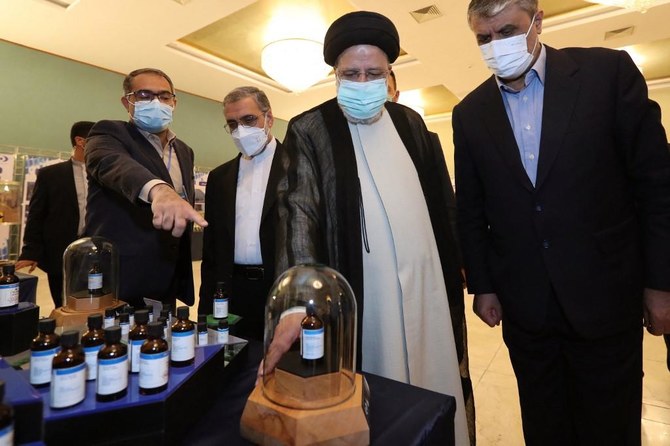 Iran’s president Ebrahim Raisi, second right, and Atomic Energy Organization of Iran chief Mohammad Eslami chief attend the Nuclear Technology Day in Tehran. (Iranian Presidency/AFP)