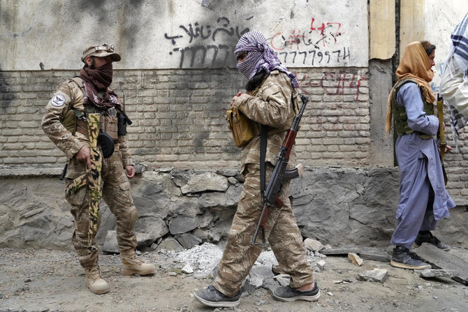 Taliban fighters stand guard at the site of a earlier explosion in front of a school in Kabul. A roadside bomb hit the same area on Thursday, April 21, 2022. (AP)