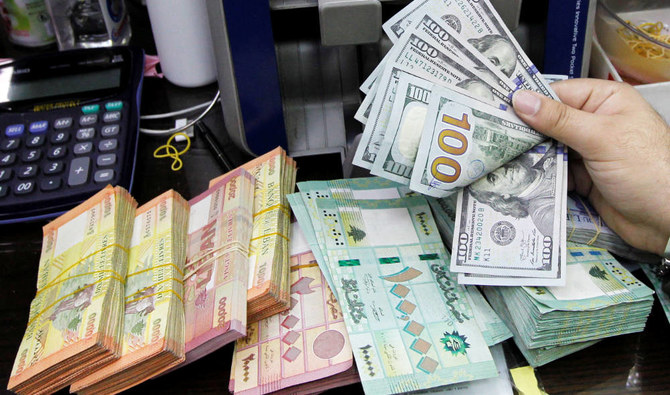 A man counts U.S. dollar banknotes next to Lebanese pounds at a currency exchange shop in Beirut, Lebanon. (REUTERS file photo)