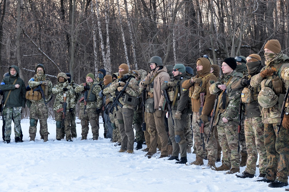 Servicemen of Ukraine's Azov Battalion pray in the Ukraine's second-biggest city of Kharkiv on March 11, 2022, following Russia's invasion of Ukraine. (AFP)