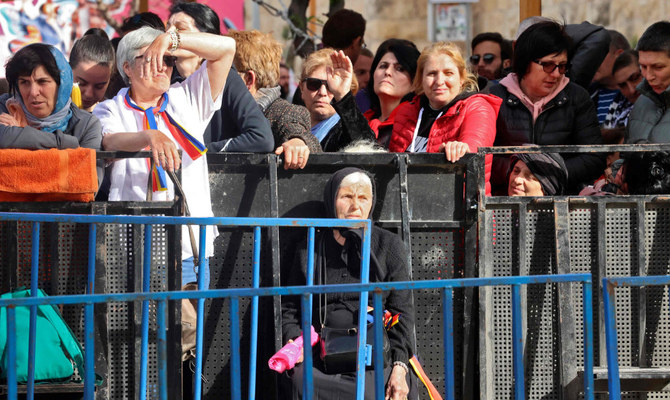 Christian worshippers wait behind barriers ahead of the Holy Fire ceremony outside Jerusalem's Holy Sepulchre church, on April 23, 2022. (AFP)