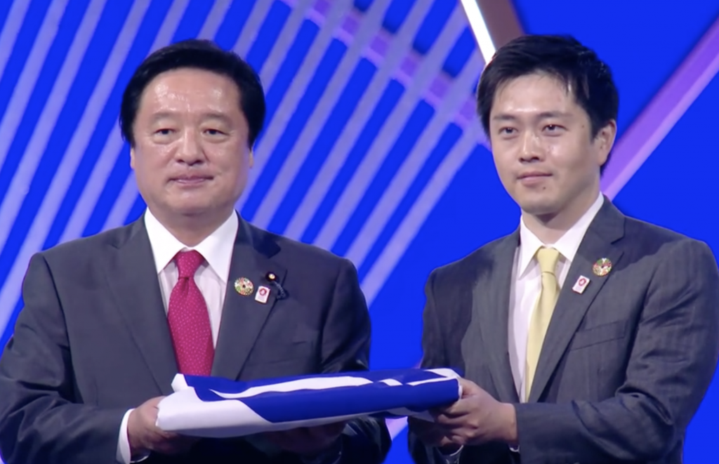 The Wakamiya Kenji, Minister for the World Expo 2025 and Yoshimura Hirofumi, Governor of Osaka Prefecture received the baton at the closing ceremony. (Screenshot)