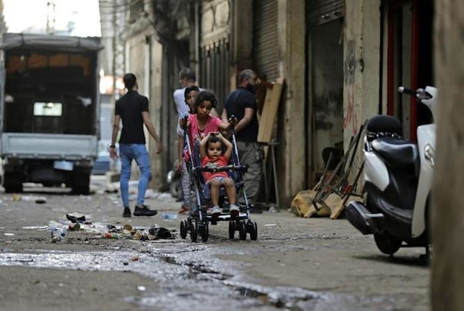 A girl pushes a child stroller in the Bab al-Tabbaneh neighborhood of Lebanon's northern city of Tripoli, hit hard by the country's worst economic crisis in decades. (AFP)