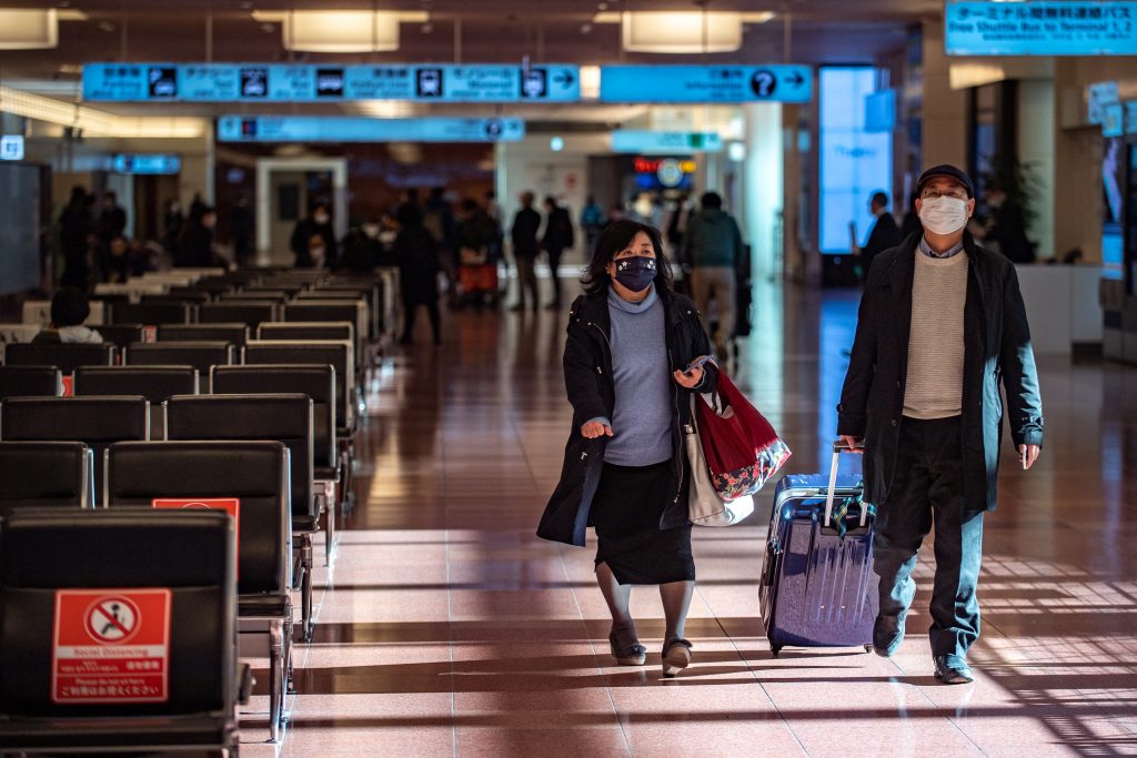 Passengers walks through the arrivals hall at Tokyo's Haneda International Airport. (AFP)