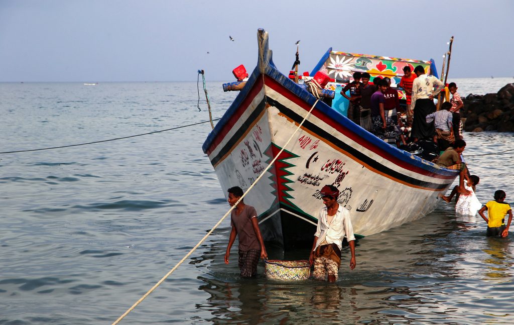 Yemeni fishermen unload their catch from boats at a beach on the Red Sea coast in the Khokha district of the western province of Hodeida, on May 7, 2022. (AFP)