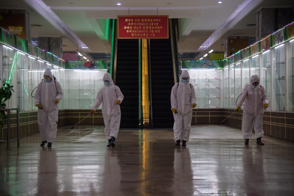 In this file photo taken on December 28, 2020 health workers spray disinfectant inside the Pyongyang Department Store No. 1 prior to opening for business, in Pyongyang on December 28, 2020. North Korea on May 12, 2022 confirmed its first-ever case of Covid-19, with state media declaring it a 