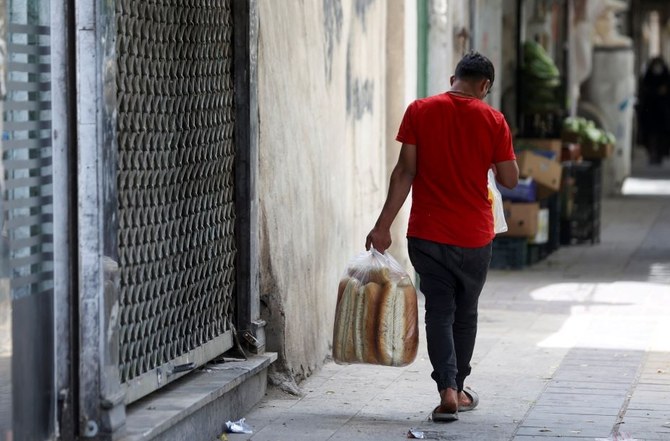 An Iranian man, carrying bread, walks along a street in Tehran, Iran, May 17, 2022. (Reuters)