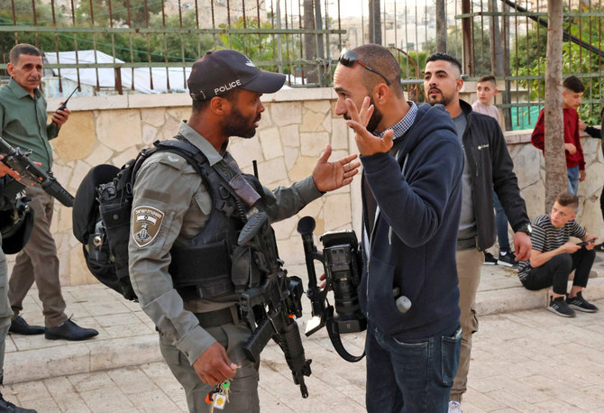 A member of the Israeli police argues with a Palestinian photographer as Muslims gather to attend the Eid Al-Fitr prayer. (AFP)