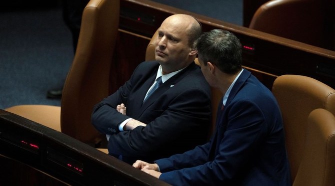 Israeli PM Naftali Bennett speaks with Minister of Communications Yoaz Hendel in the Knesset, Jerusalem, May 9, 2022. (AP Photo)