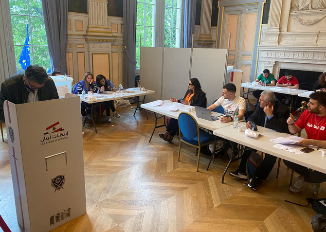 A Lebanese expat (left) casts his vote for Lebanon's parliamentary election in Paris, France, on May 8, 2022. (REUTERS/Clotaire Achi)