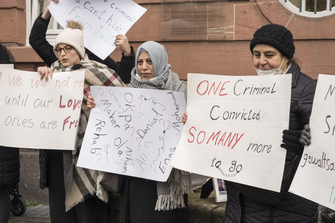People demonstrate outside the courthouse where former Syrian intelligence officer Anwar Raslan stood on trial in Koblenz, Germany, on Jan/ 13, 2022. (AFP)