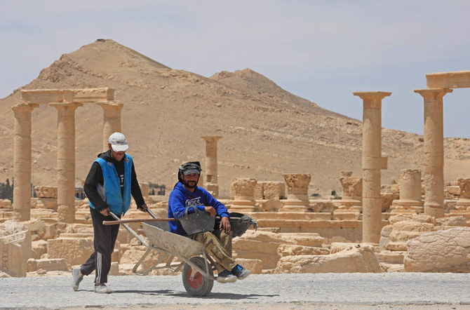 A picture shows workers at the ancient Syrian city of Palmyra on May 9, 2022. (AFP)