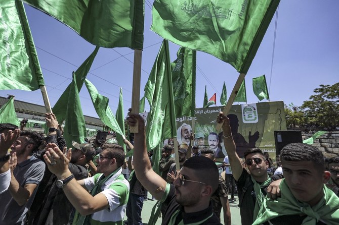 Palestinian students supporting Hamas wave the movement's flag as they celebrate a victory in student elections at Birzeit University. (File/AFP)